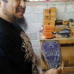 Edgar Hoill holds one of the metal plates used to print OSOK boxes.