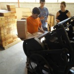 Young gentleman working the printing press.